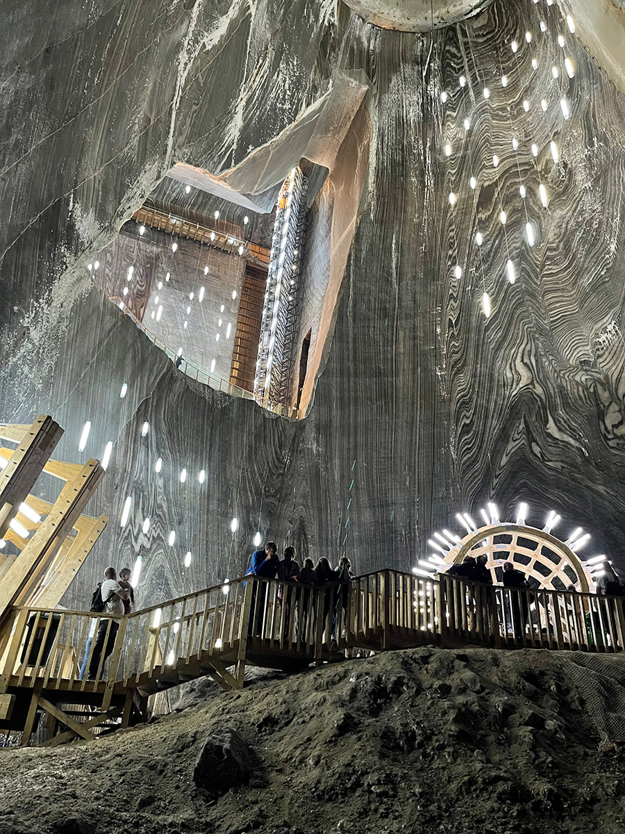 Suspended lights and walkways in the vast underground chamber at Turda Salt Mine